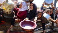 Palestinians receive lentil soup at a food distribution point in Gaza City on August 2, 2025. (Photo by Omar AL-QATTAA / AFP)
