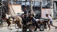 Palestinians transport men either killed or wounded while seeking food at an aid distribution point on Salah al-Din road near the Nusseirat refugee camp in the central Gaza Strip on August 2, 2025. (Photo by Eyad Baba / AFP)
