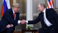 File: Russian President Vladimir Putin (right) and US President Donald Trump shake hands before a meeting in Helsinki on July 16, 2018. (Photo by Brendan Smialowski / AFP)
