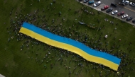 This aerial view shows protesters holding a giant Ukrainian flag in Anchorage, Alaska, on August 15, 2025 during a US-Russia summit. (Photo by Daphné Lemelin / AFP)