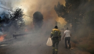 People fight a wildfire in the village of Vilarino, in Carballeda de Avia municipality, northwestern Spain, on August 17, 2025. Photo by MIGUEL RIOPA / AFP