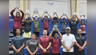 Qatar players lift their trophies as they celebrate with officials.