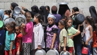 Palestinians gather to receive cooked meals from a food distribution center in the Nuseirat refugee camp in the central Gaza Strip on August 18, 2025. Photo by Eyad BABA / AFP