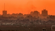 This picture taken from a position on Israel's border with the Gaza Strip shows destroyed buildings in the besieged Palestinian territory at sunset on August 21, 2025. (Photo by Jack Guez / AFP)