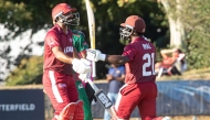 Qatar's Imal Liyanage (right) celebrates after reaching his century.