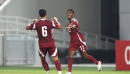 Mohamed Siraj (right) celebrates with a teammate after scoring Qatar's fourth goal.