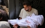 A Palestinian man carries the shrouded body of a child killed in Israeli strikes on Gaza City at dawn, during a funeral procession outside the Al-Shifa hospital on September 4, 2025, amid the war between Israel and the Hamas militant movement. (Photo by Omar AL-QATTAA / AFP)
