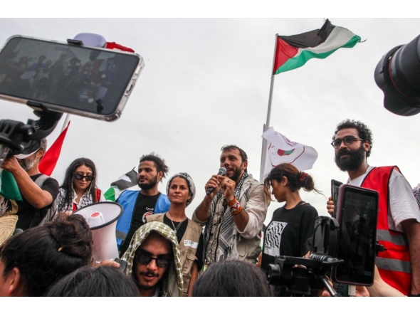 Brazilian activist Thiago Avila speaks to the crowd of pro-Palestinian activists that arrived to greet the Global Sumud Flottila at the port of the village of Sidi Bou Said on September 7, 2025. (Photo by Yassine Mahjoub / AFP)