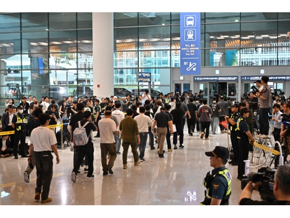 South Korean workers arrive at Incheon International Airport in Incheon on September 12, 2025, after the touch down of a specially chartered Korean Air Boeing 747-81 (KE9036) bringing hundreds of South Korean workers back from Atlanta after their detention in a US immigration raid at a Hyundai-LG plant in Ellabell, Georgia. (Photo by Anthony WALLACE / AFP)
