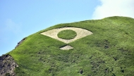 Grass mowed into the shape of a fan bearing the Japanese flag is seen on a mountain in Aso, Kumamoto Prefecture. Photo by The Japan News
