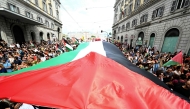 People march with a giant Palestinian flag during a nationwide strike 