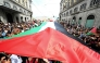 People march with a giant Palestinian flag during a nationwide strike 