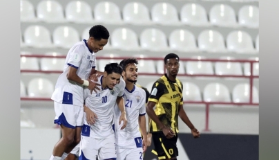 Al Kharaitiyat players celebrate after scoring a goal.