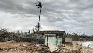 A fishing boat is washed ashore near houses in Calayan island, Cagayan province on September 23, 2025, a day after Super Typhoon Ragasa hit the island.  (Photo by Cristy Gaffud / AFP)