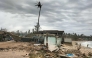 A fishing boat is washed ashore near houses in Calayan island, Cagayan province on September 23, 2025, a day after Super Typhoon Ragasa hit the island.  (Photo by Cristy Gaffud / AFP)