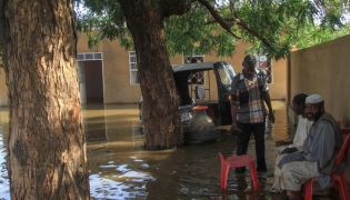 Residents sit in a pool of water due to the flooding of the Nile river in the Sudanese village of Wad Ramli north of Khartoum on October 1, 2025. (Photo by Ebrahim Hamid / AFP)
