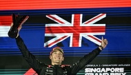 First-placed Mercedes' British driver George Russell celebrates on the podium after the Formula One Singapore Grand Prix night race at the Marina Bay Street Circuit in Singapore on October 5, 2025. (Photo by Lillian SUWANRUMPHA / AFP)