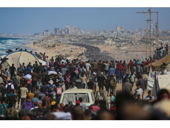 Palestinians walk along Al-Rashid road toward Gaza City from Nuseirat in the central Gaza Strip on October 10, 2025. (Photo by Bashar Taleb / AFP)