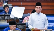 This handout photo taken and released by Malaysia's Department of Information on October 10, 2025 shows Malaysia's Prime Minister and Finance Minister Anwar Ibrahim delivering his speech on the 2026 national budget at the Parliament in Kuala Lumpur. (Photo by Nazri RAPAAI / DEPARTMENT OF INFORMATION / AFP
