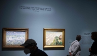 People view paintings by French artist Claude Monet on display at the 