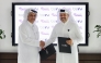 beIN Consumer Sales Manager Hamad Aljaber and Rafeeq Media Manager Ahmed Abdulla exchange documents during the ceremony. 