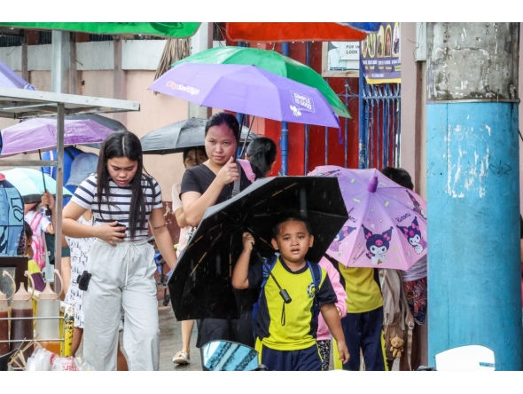 A student holds an umbrella outside a school after classes were suspended due to the tropical storm Wipha in Quezon City, the Philippines, on July 18, 2025. (Xinhua/Rouelle Umali)
