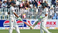 Pakistan's captain Shan Masood (L) and his teammate Babar Azam bump their bats during the first day of the second Test cricket match between Pakistan and South Africa at the Rawalpindi Cricket Stadium in Rawalpindi on October 20, 2025. (Photo by Aamir QURESHI / AFP)
