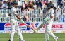 Pakistan's captain Shan Masood (L) and his teammate Babar Azam bump their bats during the first day of the second Test cricket match between Pakistan and South Africa at the Rawalpindi Cricket Stadium in Rawalpindi on October 20, 2025. (Photo by Aamir QURESHI / AFP)
