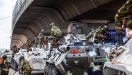 Bangladeshi soldiers disembark armored vehicles as they patrol the streets to disperse the anti-quota protesters in Dhaka on July 20, 2024. (Photo by AFP)
