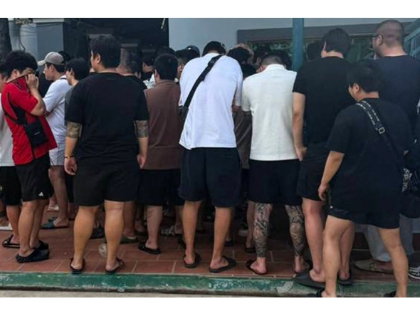 This undated handout from Agence Kampuchea Press (AKP) released on October 23, 2025 shows people, suspected of being involved in online scams, gathering during a raid on a scam centre in Phnom Penh. (Photo by Handout / Agence Kampuchea Press (AKP) / AFP)