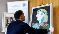 Patrick Haggenmueller, Head of the Art Investigation Unit of the Bavarian State Criminal Police Office (BLKA), displays the forged painting 'Portrait of Marie-Therese Walter with garland', offered as artwork by Spanish artist Pablo Picasso and confiscated by the police, during a presentation in the premises of the Bavarian State Criminal Investigation Department in Munich, southern Germany, on October 24, 2025. Photo by Matthias BALK / AFP