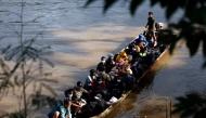 People from various countries, who were working in the KK Park compound in Myanmar, travel in a boat across the Moei river to cross over from Myanmar to Thailand, as seen from Mae Sot District, Tak Province area on October 24, 2025. (Photo by Sarot Meksophawannakul / THAI NEWS PIX / AFP)
