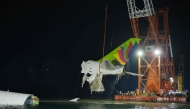Crane hoisting the recovered the tail section an ACT Airlines Boeing 747-400 cargo aircraft released on October 25. Photo by Handout / Airport Authority Hong Kong / AFP) 