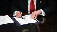 US President Donald Trump signs the bill package to re-open the federal government in the Oval Office of the White House in Washington, DC, on November 12, 2025. (Photo by Brendan Smialowski / AFP)