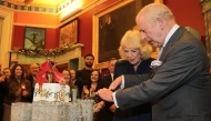 Britain's King Charles III and Britain's Queen Camilla cut into a castle-styled cake at a celebratory reception to mark the 200th anniversary of Cyfarthfa Castle during a visit to the South Wales town of Merthyr Tydfil on November 14, 2025, on the King's 77th birthday. Photo by Kin Cheung /  AFP