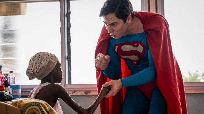Leonardo Muylaert, known as the Brazilian Superman, greets a patient during a visit at the Korle Bu Teaching Hospital in Accra. (Photo by Claudia Lacave / AFP)