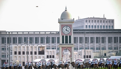 Camel-mounted royal guards patrol around the Amiri Diwan in Doha on November 13, 2025. (Photo by MAHMUD HAMS / AFP)