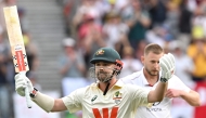 Australia's Travis Head celebrates reaching his century (100 runs) on day 2 of the first Ashes cricket Test match between Australia and England at Perth Stadium in Perth on November 22, 2025. (Photo by Saeed Khan / AFP)