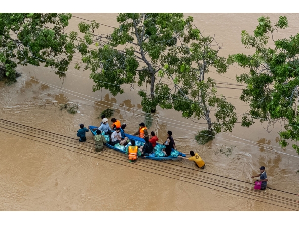 This aerial photo shows people wading through floodwaters in Phan Rang in southern Vietnam's Khanh Hoa province on November 21, 2025. (Photo by Bao Quan / AFP)
