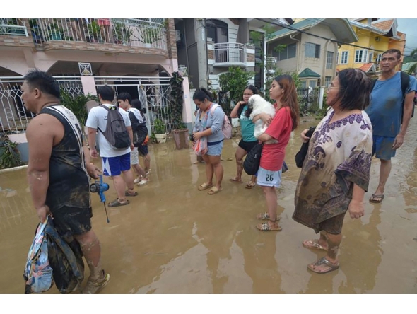 Residents stand in the mud as they wait to be evacuated from their flood-hit homes after Typhoon Kalmaegi hit Cebu City in the central Philippines on November 4. Photo by Alan Tangcawan / AFP