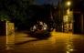 People ride on a boat belonging to Sri Lanka's army at a flooded street after heavy rainfall in Wellampitiya on the outskirts of Colombo on November 30, 2025. (Photo by Ishara S. KODIKARA / AFP)
