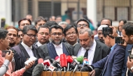 prosecutor for the Anti-Corruption Commission Khan Mainul Hasan (C), addresses the media at a court premises in Dhaka on December 1, 2025. (Photo by Munir Uz Zaman / AFP)