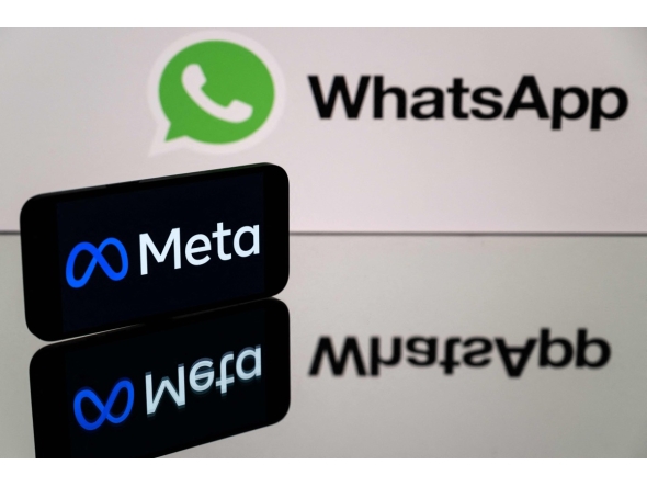 This photograph taken on January 12, 2023 in Toulouse, southwestern France shows a smartphone and a computer screen displaying the logos of WhatsApp app and its parent company Meta. Photo by Lionel BONAVENTURE / AFP