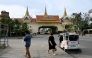 People walk near the closed Poipet International border checkpoint between Cambodia and Thailand in Poipet, Banteay Meanchey province on December 12, 2025, amid clashes along the Cambodia-Thailand border. (Photo by TANG CHHIN Sothy / AFP)
