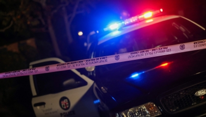 A Los Angeles Police Department patrol car is seen behind police tape blocking the access to a house in the Brentwood neighborhood of Los Angeles, California, on December 14, 2025. (Photo by Michael Tran / AFP)
