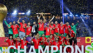 Morroco's players celebrate with the trophy after winning the FIFA Arab Cup 2025 final football match between Jordan and Morocco at the Lusail Stadium Stadium, in Lusail on December 18, 2025. (Photo by Karim JAAFAR / AFP)
