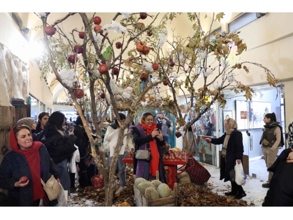 Iranians celebrate with Yalda decoration in northern Tehran on December 20, 2025, in preparation for the annual festival of Yalda. (Photo by -STR / AFP)