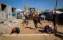 Palestinian municipality workers repair a road damaged during the war in the Nuseirat camp for the displaced in the central Gaza Strip on December 22, 2025. (Photo by Eyad Baba / AFP)