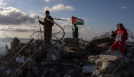 Children pose for photos taken by their parents on the rubble of a house demolished by Israeli authorities in the Palestinian village of Bizariya, in the Israeli-occupied West Bank, on December 24, 2025. (Photo by Zain JAAFAR / AFP)
