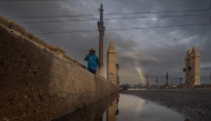 A rainbow is seen over the 4th Street Bridge after heavy rains in downtown Los Angeles on December 24, 2025. (Photo by Apu Gomes / AFP)